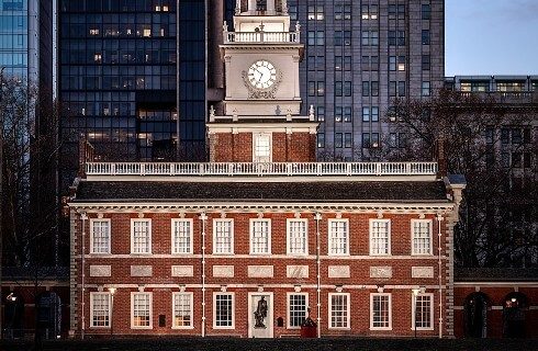 Large two-story red brick building with sixteen windows and clock tower