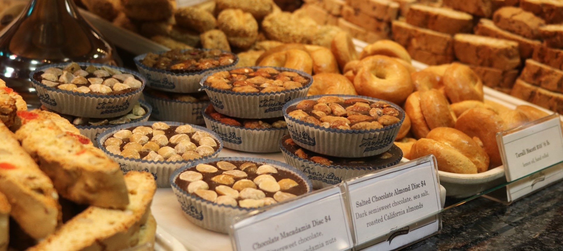 Display case full of delicious baked goods including bagels, tarts and breads