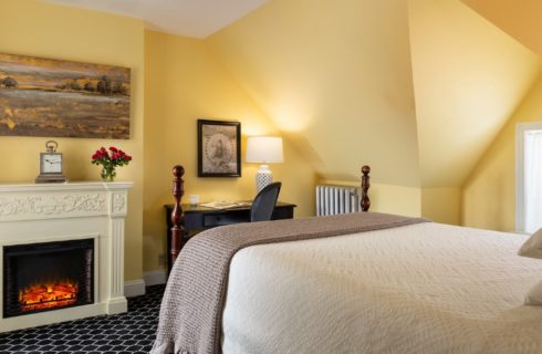 Cozy guest suite with fireplace, sitting table and yellow walls