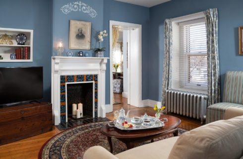 Cozy sitting room with couch, coffee table, fireplace and chest with a TV